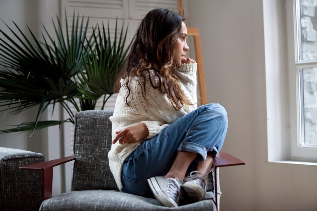 Sad thoughtful girl sitting on chair feeling anxiety depressed or lonely absolutely adell